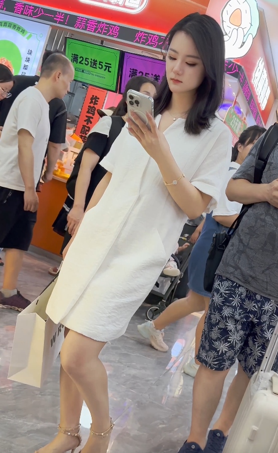 街拍白裙少妇专注玩手机单部287MB微透诱惑